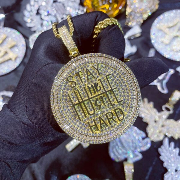 Close-up of gold pendant held in hand, luxury hip hop jewelry for men.
