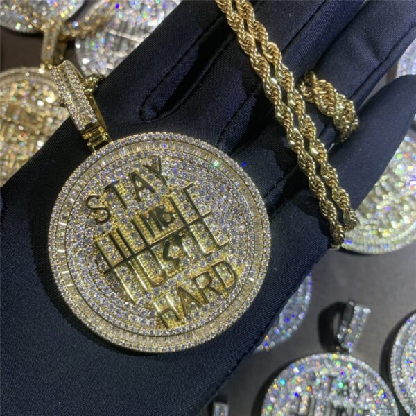Gold bling pendant held in hand, iced out chain for men, hip hop accessories.